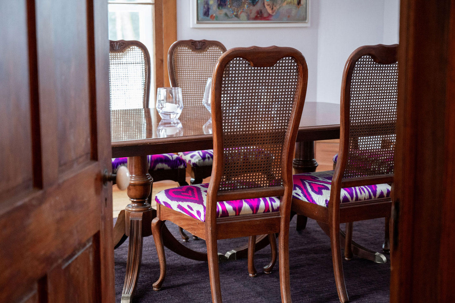 Dining table with colorful chairs.