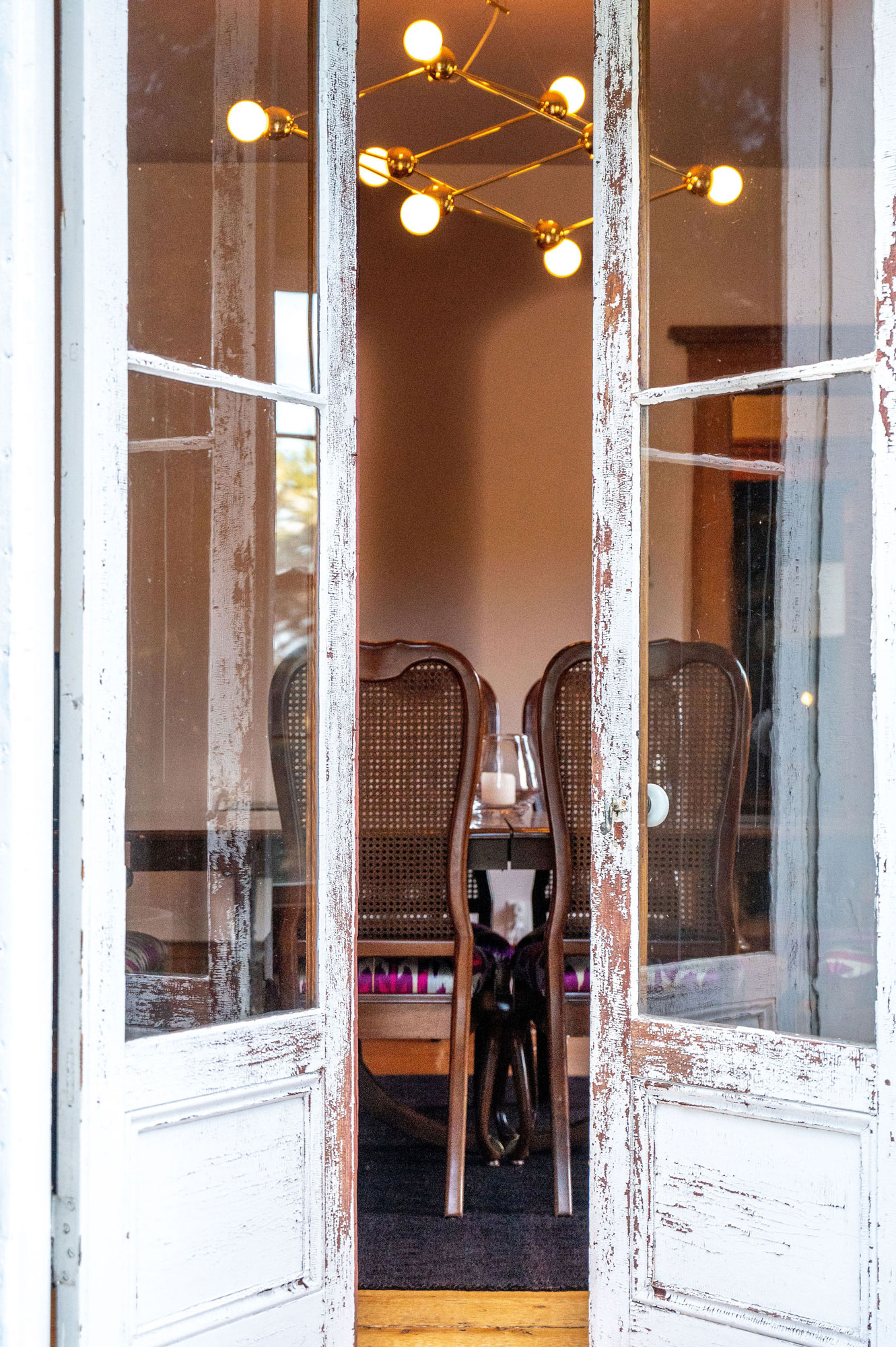 Open French doors leading from the bluestone terrace into the dining room.