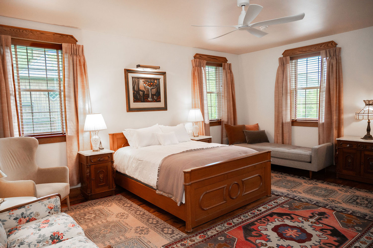 The Cobble House Frances Suite photo of the Frances Suite showing a large bed with carved headboard, a love seat, aand aa daybed.