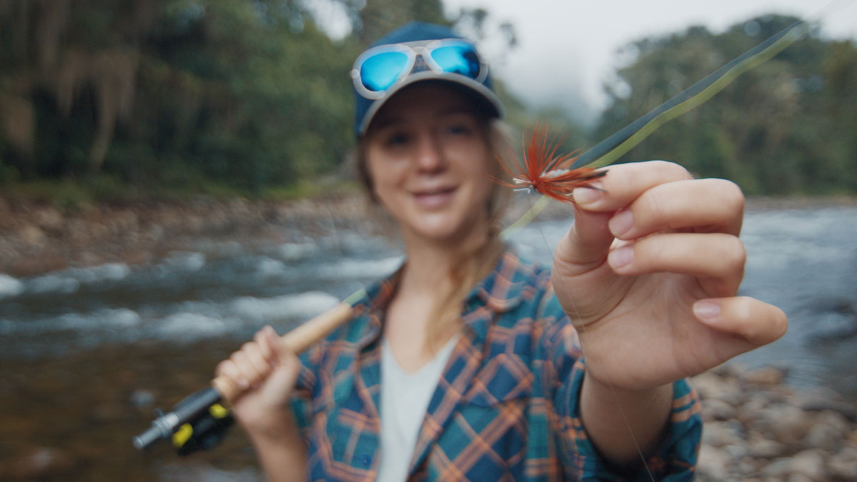 Woman holding up a fly lure.