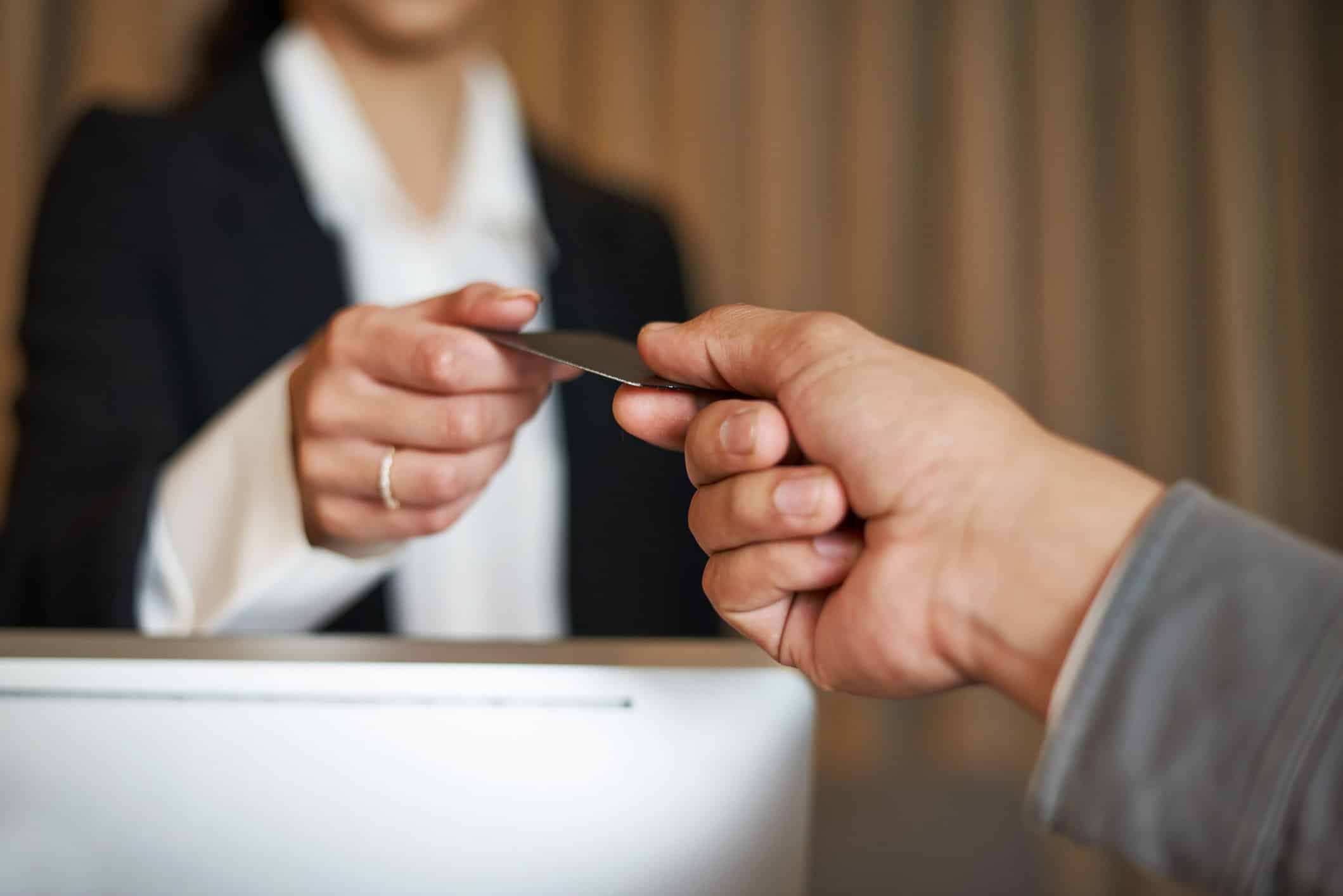 hotel cost Closeup of a hand handing a hotel receptionist a credit card